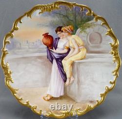 Assiette de 13 1/2 pouces peinte à la main et signée Dubois représentant des femmes grecques et une ville de Limoges, années 1890.