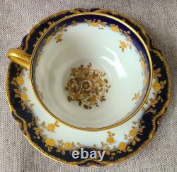 Ensemble de tasse à thé et soucoupe antique Haviland Limoges avec des roses en relief en or et un bleu cobalt.