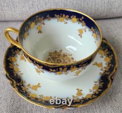 Ensemble de tasse à thé et soucoupe antique Haviland Limoges avec des roses en relief en or et un bleu cobalt.