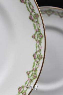 Service de neuf assiettes plates en porcelaine de Limoges français par M. Redon, guirlandes de roses avec dorures.