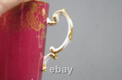 Tasse à chocolat JP Pouyat Limoges peinte à la main, en cranberry et or, avec motifs floraux et volutes.